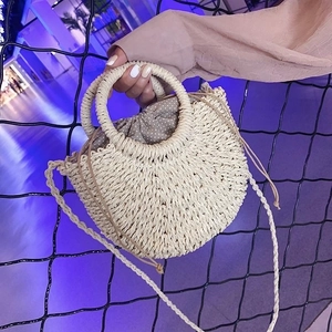 Handmade round straw woven handbag for women, stylish summer beach shoulder bag with handles.