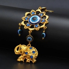Detailed view of Hamsa Hand and Evil Eye pendant with golden elephant decor