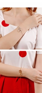 Close-up of gold and silver heart cat paw bracelets with thin O-chains on model wrist