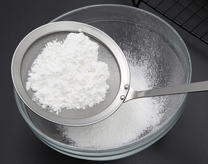 Macro detail of 304 stainless steel fine mesh strainer sifting white powder for baking