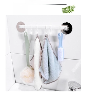Detail of white 6-hook wall rack holding a bath towel and sponge brush in bathroom