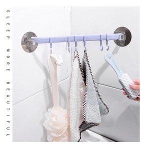 Macro detail of 6-hook wall rack in light purple with hanging bath ball on white tiles