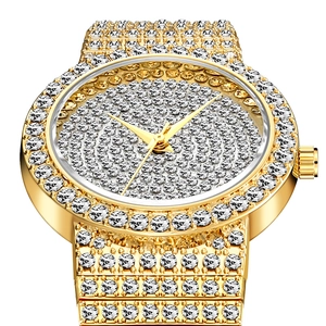 Luxury gold women's watch fully iced out with sparkling crystals on white background