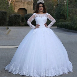 Elegant long-sleeved white lace wedding gown with voluminous tulle skirt and floral appliques