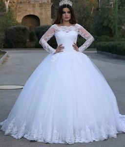 Close-up of elegant off-the-shoulder lace sleeves and bodice on a white bridal gown
