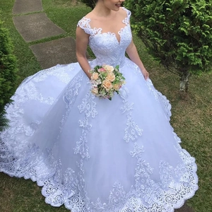 Elegante witte trouwjurk met V-hals, kant, open rug en een indrukwekkende lange sleep