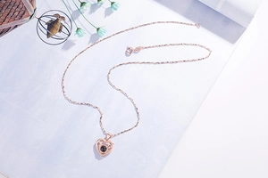 Detailansicht der roségoldenen Herz-Geweih-Halskette mit Projektionsstein und Diamanten