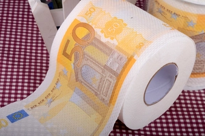 Close-up of novelty toilet paper roll with 50 Euro banknote print on a checkered cloth