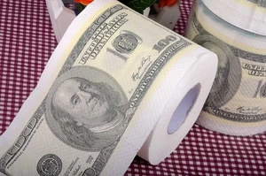 Detail of toilet paper printed with realistic 100 dollar bill pattern on table