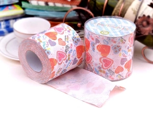Detail of printed toilet paper roll showing red heart patterns and decorative text