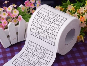 Detail view of novelty toilet paper roll printed with black Sudoku puzzle patterns