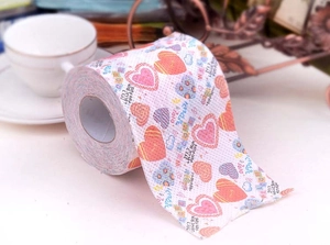 Detail of printed toilet paper featuring pink and blue heart patterns and English text