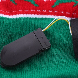 Detailed view of the internal LED battery control switch on a Christmas knit hat