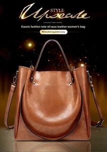 Close-up of vintage tan oil-waxed leather tote bag with silver rivets and metal hardware