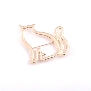 Detailed close-up of a golden hollowed-out cat brooch with a polished metal surface