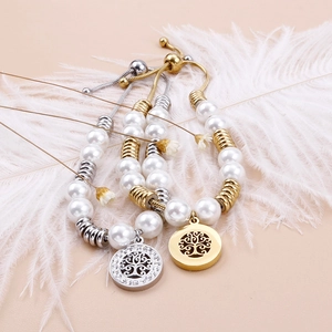 Adjustable pearl bracelet with tree of life charms in gold and silver finish on feathers