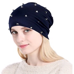 Gros plan sur un bonnet en maille bleu marine avec clous métalliques argentés