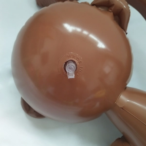 Close-up of inflatable toy valve with Made in China engraving on brown PVC surface