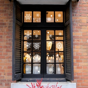 White snowflake window stickers for Christmas glass decoration on black wooden pane window