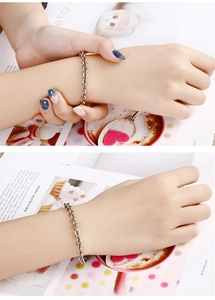Close-up of minimalist silver titanium steel chain bracelet worn on a model wrist
