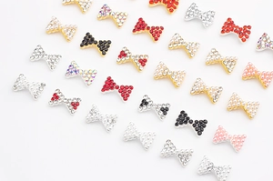 Détails de bijoux d'ongles en forme de nœud avec strass étincelants et perles nacrées