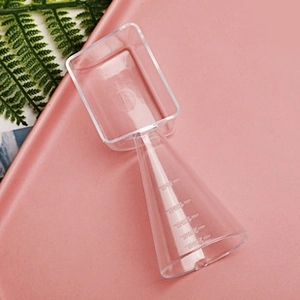 Close-up of clear plastic measuring scoop with dual-head design and volume scale