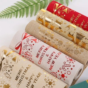 Christmas table runner rolls with gold foil reindeer and tree patterns on linen fabric