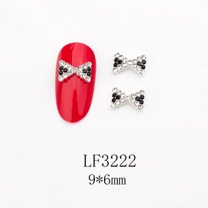 Vue détaillée des bijoux à ongles nœuds avec cristaux et dimensions 9x6 mm sur ongle rouge
