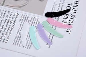 Detailed view of six colorful cosmetic spatulas with ergonomic curved handles and glossy finish