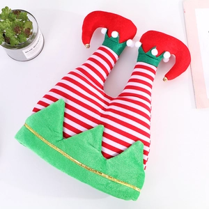 Funny Christmas elf legs hat with red white stripes and bells on white table