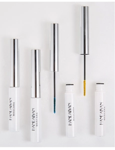 Detailed macro view showing blue and yellow mascara wands with white tubes and silver caps
