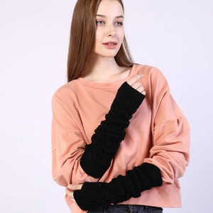 Close-up of black cable-knit arm warmers featuring thick textured patterns and fingerless design