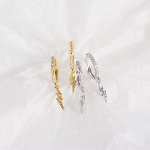Close-up of gold and silver S925 sterling silver lightning bolt earrings with pavé diamonds