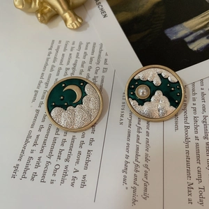 Detailed view of vintage enamel moon and star brooches with pearl and gold accents