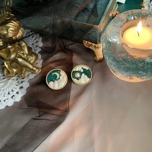 Macro shot of vintage round green enamel earrings with gold moon and cloud patterns