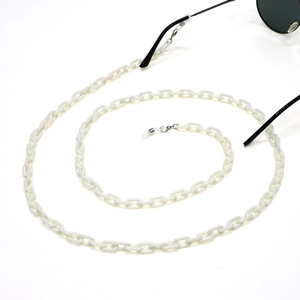 Close-up of white acrylic eyeglass chain with silver lobster clasps and silicone loops