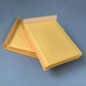 Stack of yellow kraft paper bubble mailers with self-sealing strips for secure shipping