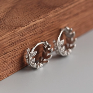 Close-up of S925 sterling silver hoop earrings with olive leaf cubic zirconia pavé