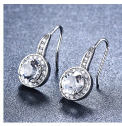 Macro detail of silver tassel earrings with round cubic zirconia and hook closure