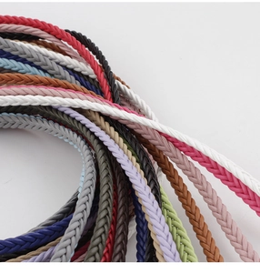 Close-up of woven braided belts in various colors on a white background