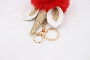 Detail of red plush unicorn keychain with gold glitter horn and metallic gold clasp