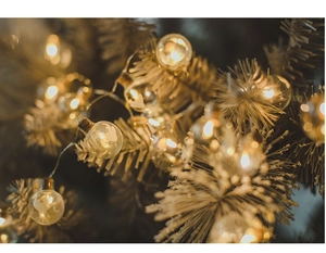 Macro view of warm yellow spherical Christmas globe lights featuring reindeer patterns