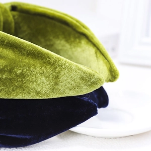 Detail of velvet knotted headbands showing fabric texture in green and navy blue