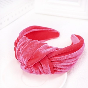 Close-up of velvet knot headband in vibrant rose pink with soft textured fabric