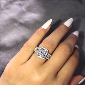 Macro shot of luxury emerald-cut zircon ring with halo diamonds on a plush background