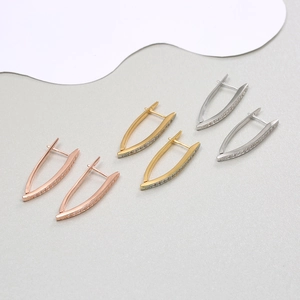 Detailed view of three V-shaped hoop earrings in rose gold, gold and silver with cubic zirconia