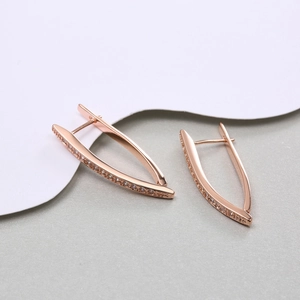 Macro shot of rose gold V-shaped hoop earrings with sparkling cubic zirconia pavé