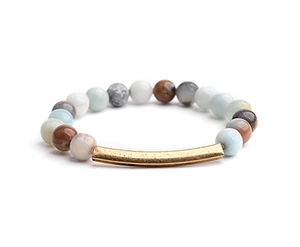 Detail of natural stone beaded bracelet featuring multi-color beads and golden metal tube