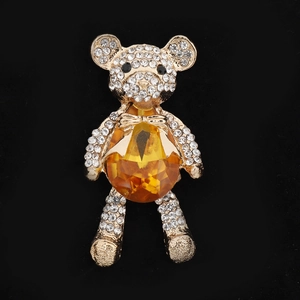 Macro shot of gold-plated bear pendant featuring yellow gemstone and white rhinestones