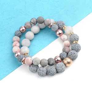 Lava stone and marble beaded bracelet set with rose gold accents on blue background